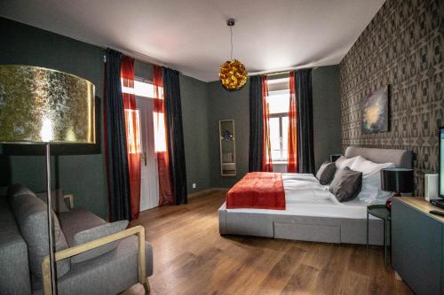 een slaapkamer met een bed, een stoel en een bank bij Ruterra Apartments by Cathedral in Praag