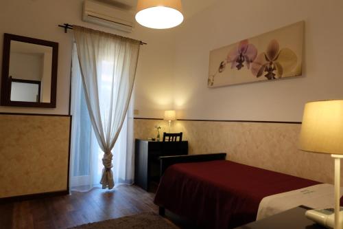 una camera d'albergo con letto e finestra di Hotel Villa Nettuno a Taormina