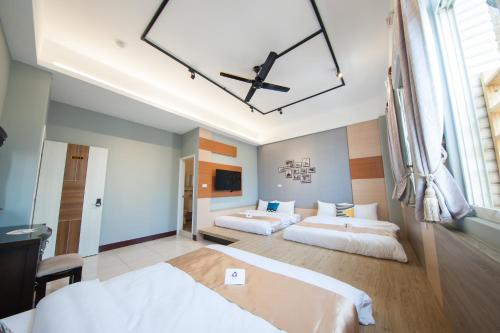 a bedroom with two beds and a ceiling fan at D.C. Inn in Magong