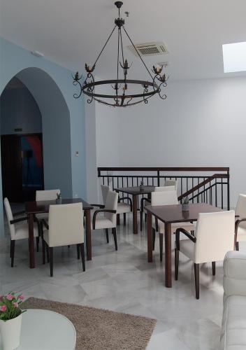 a dining room with tables and chairs and a chandelier at Hotel Boutique Convento Cádiz in Cádiz