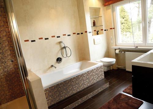 a bathroom with a bath tub and a toilet at Inn66 in Amecke