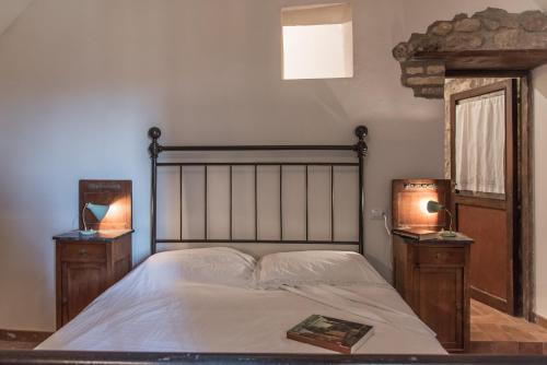 Un dormitorio con una cama con dos mesitas de noche y un espejo. en Foresteria Terra Majura, en Terni