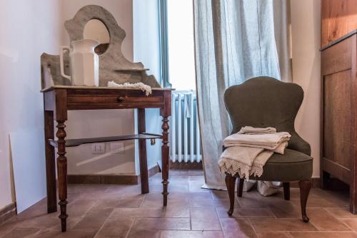 una silla sentada junto a una mesa y un espejo en Foresteria Terra Majura, en Terni