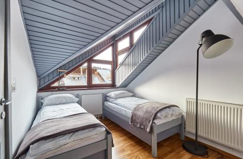 a attic bedroom with two beds and a lamp at Rezident Predeal in Predeal