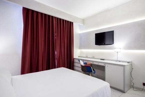 a hotel room with a bed and a desk with a television at Best Western Modena District in Campogalliano
