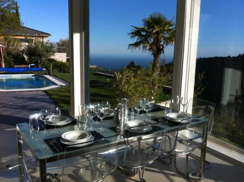 - une table en verre avec des verres à vin dans l'établissement Villa Mia, à Castillon