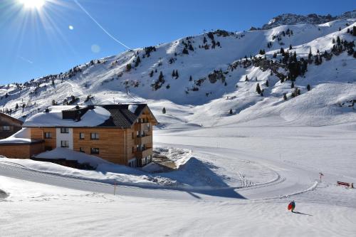 a building on a snow covered slope with a mountain at apart-wolf-arlberg in Warth am Arlberg