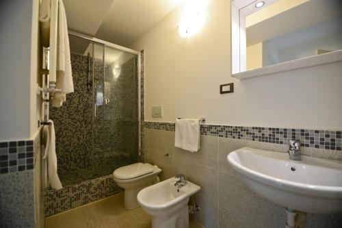 a bathroom with a sink and a toilet and a shower at Residence La Fontaine in Venice-Lido