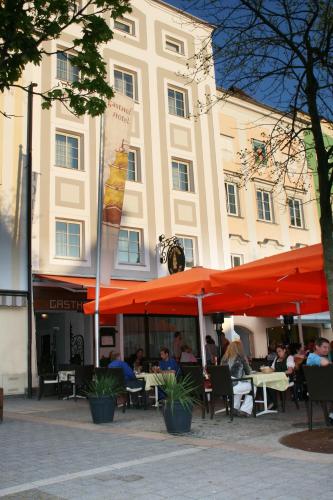 people sitting at tables in front of a building at Appartement-Hotel GH Zum Goldenen Schiff in Enns