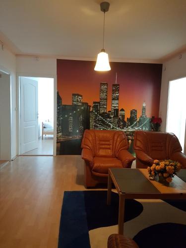 a living room with two chairs and a city at Golden Danube in Veliko Gradište