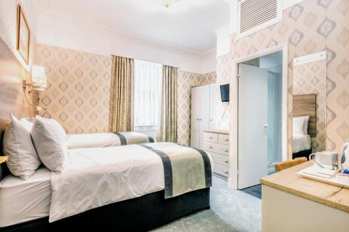 a hotel room with a bed and a desk at Lindum Lodge in Torquay