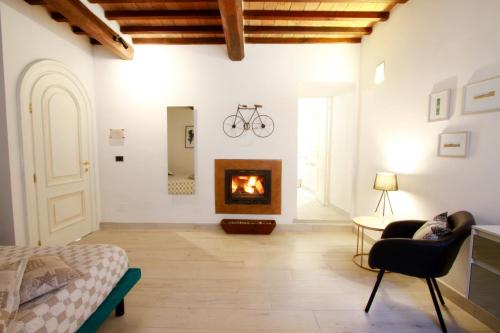 a living room with a fireplace and a bed at La Casa nel Borgo in Monticchiello