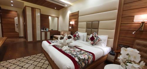 a hotel room with a bed with two stuffed animals on it at Hotel Makhan Residency in Amritsar
