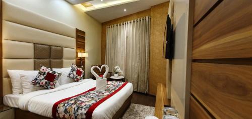 a hotel room with a bed and a television at Hotel Makhan Residency in Amritsar