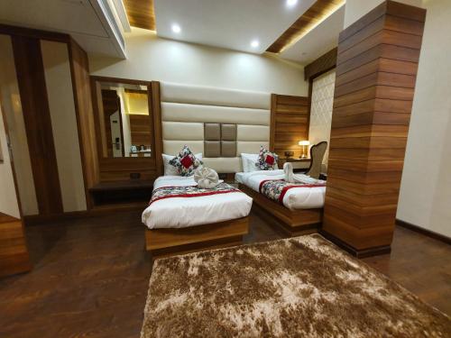 a hotel room with two beds and a mirror at Hotel Makhan Residency in Amritsar