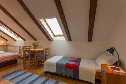 a bedroom with a bed and a table with a lamp at Pension Kezele in Graberje Ivanićko