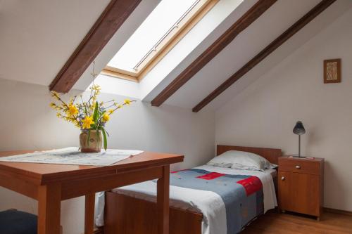 a bedroom with a bed and a table with flowers on it at Pension Kezele in Graberje Ivanićko