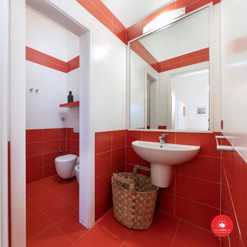 a red bathroom with a sink and a toilet at Fattoria Battilana in Marina di Carrara