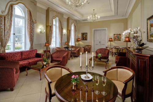 a living room with a table and chairs at La Contessa Castle Hotel in Szilvásvárad