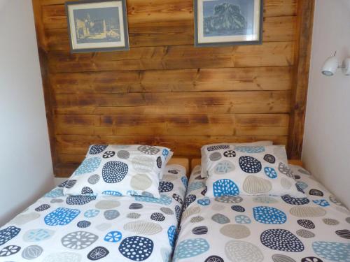 two twin beds in a room with two pictures on the wall at Country House Speedy in Komiža