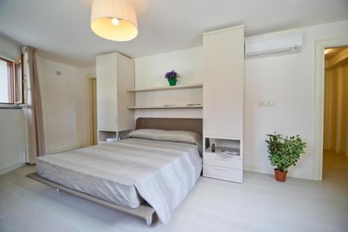 a bedroom with a bed in a white room at Residence La Fontaine in Venice-Lido