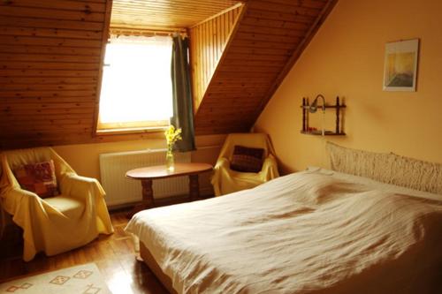 a bedroom with a bed and a table and a window at Hangulat Vendégház / Apartman in Harkány