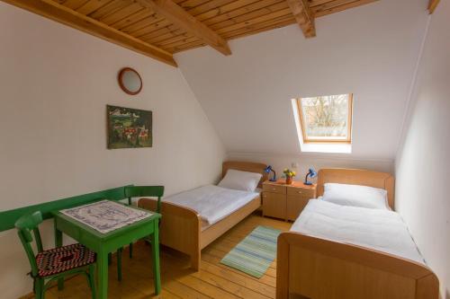 Habitación pequeña con 2 camas y mesa. en Pension Kezele, en Graberje Ivanićko