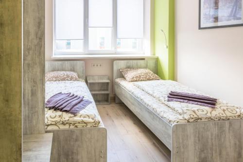 two beds in a room with two windows at Art хостел-готель "Адреналін" in Luts'k