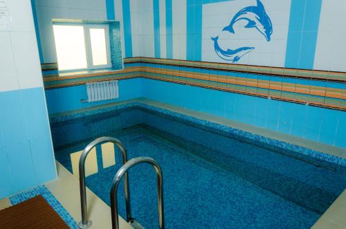 a swimming pool with two chairs and a window at Tarmansky Hotel in Tyumen