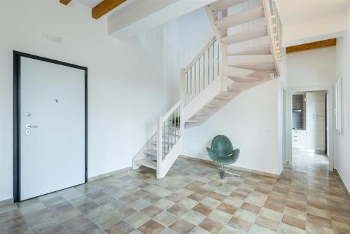 a room with a staircase and a green chair at Dimora Villa Ada in Chiaramonte Gulfi
