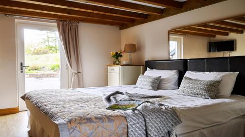 a bedroom with a large bed and a window at Barcud House in Devils Bridge