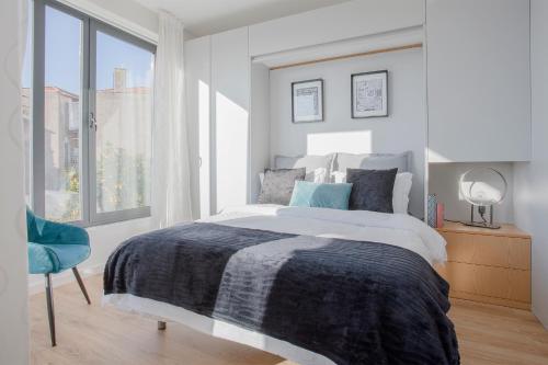 a white bedroom with a bed and a window at Liiiving in Porto I Bright Light Studio in Porto