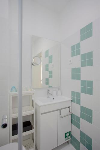 a white bathroom with a sink and a mirror at Liiiving in Porto I Bright Light Studio in Porto