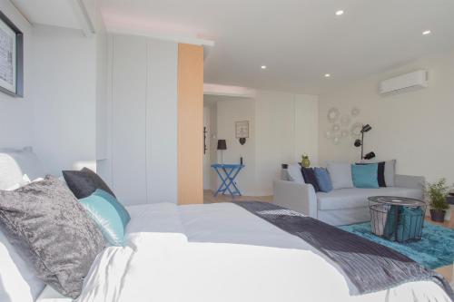 a bedroom with a white bed and a couch at Liiiving in Porto I Bright Light Studio in Porto