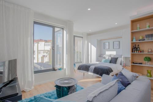 a white living room with a bed and a couch at Liiiving in Porto I Bright Light Studio in Porto