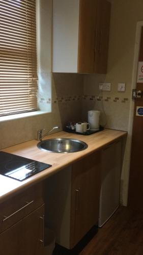 a kitchen with a sink and a counter top at The Bull and Bush Hotel Kingston in Kingston upon Thames