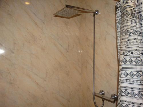 a shower in a bathroom with a shower curtain at The Bull and Bush Hotel Kingston in Kingston upon Thames