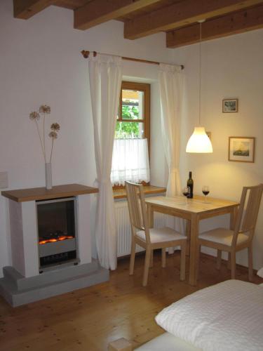 a living room with a table and a fireplace at Haus der Sonne in Kötschach