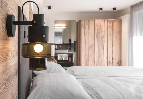 a bedroom with a bed with a light on the wall at Brunnerhof Klausen-Chiusa in Chiusa