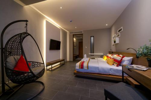 a hotel room with a bed and a swing at The Gallery Hotel Nai Harn in Nai Harn Beach