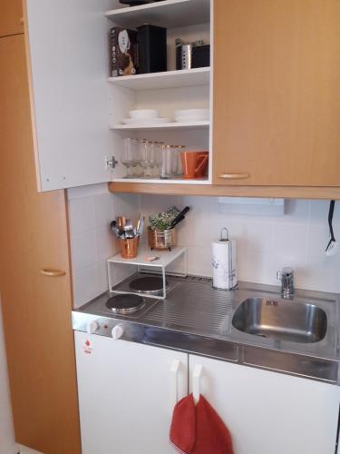 a small kitchen with white cabinets and a sink at Hamina Orange Apartments Loft in Hamina