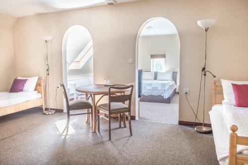 a room with a table and chairs and a bedroom at Karle Hotel in Vitrupe