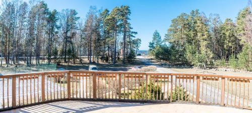 a wooden deck with trees in the background at Karle Hotel in Vitrupe