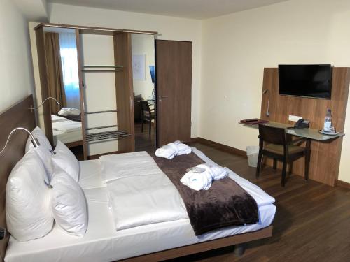 a hotel room with a bed and a desk at Hotel Isenbütteler Hof in Isenbüttel