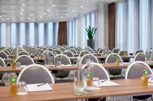
a room filled with tables and chairs filled with chairs at Hyperion Hotel München in Munich

