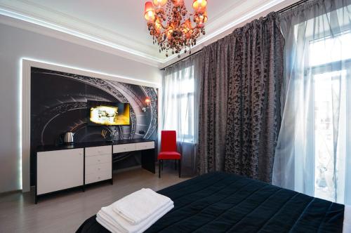 a bedroom with a bed and a tv and a chandelier at Partner Guest House Velyka Vasylkivska in Kyiv