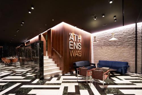 a lobby with chairs and a staircase in a building at AthensWas Design Hotel in Athens