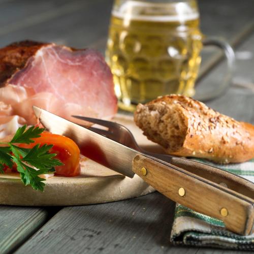 a cutting board with meat and bread and a knife at Bauer & Wirt Langthaler in Emmersdorf an der Donau