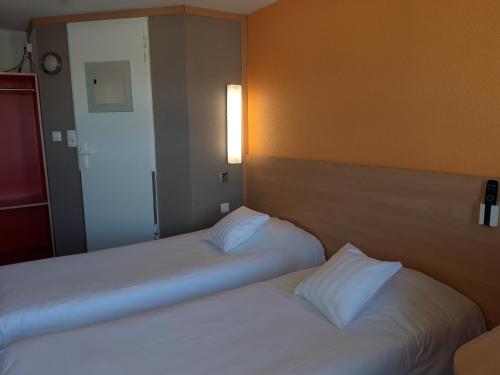 
a hotel room with two beds and a lamp at Premiere Classe Liege / Luik in Liège
