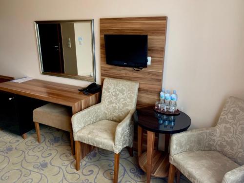 a room with a desk and two chairs and a television at Hotel Komfort in Krzywaczka